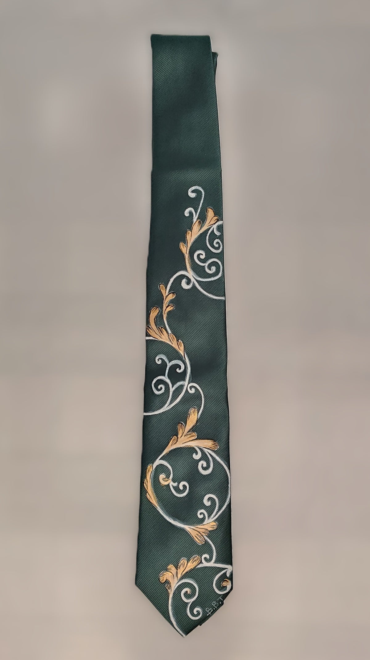 Cravatta verde scuro con ghirigori bianchi e oro
