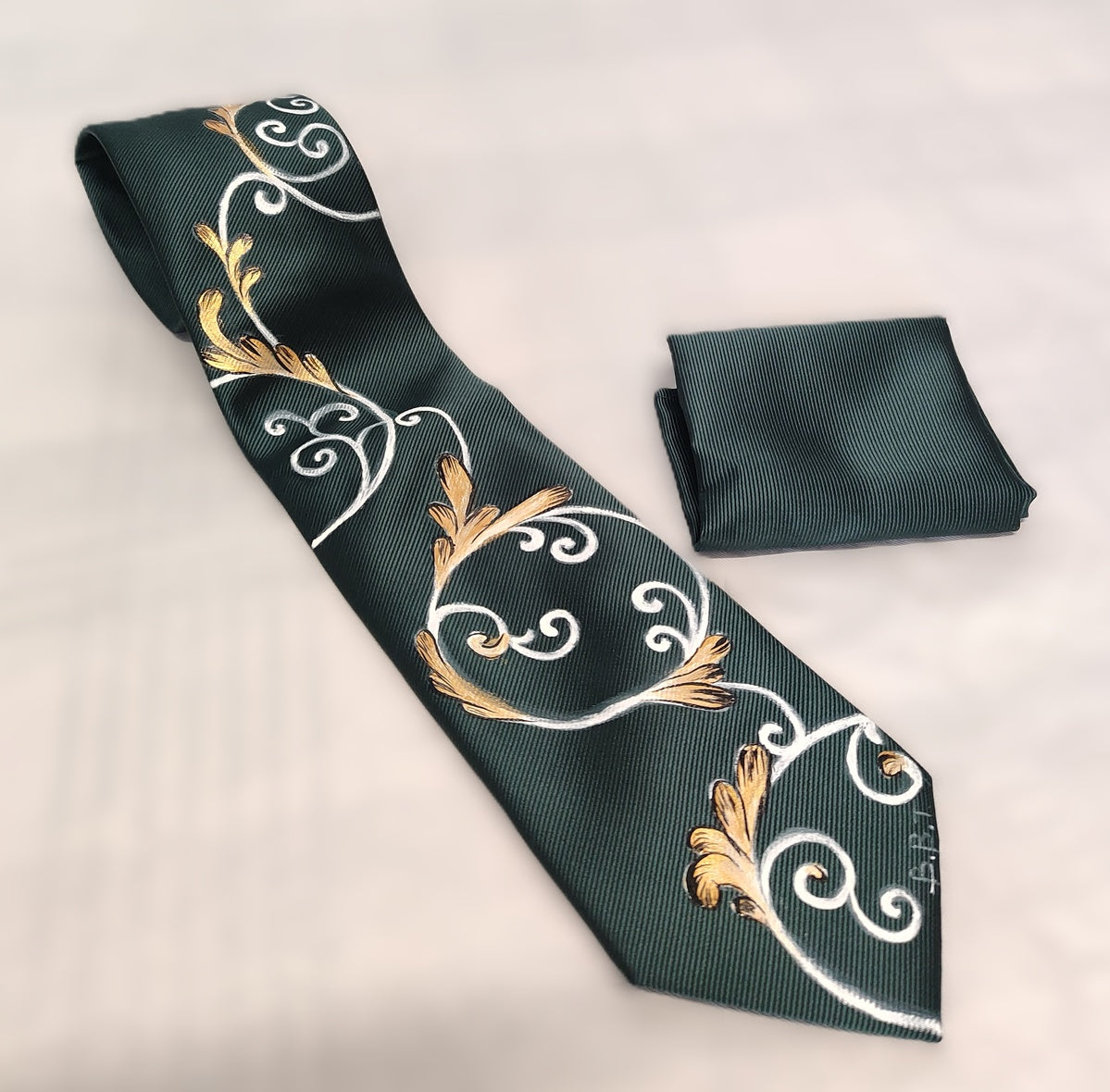 Cravatta verde scuro con ghirigori bianchi e oro
