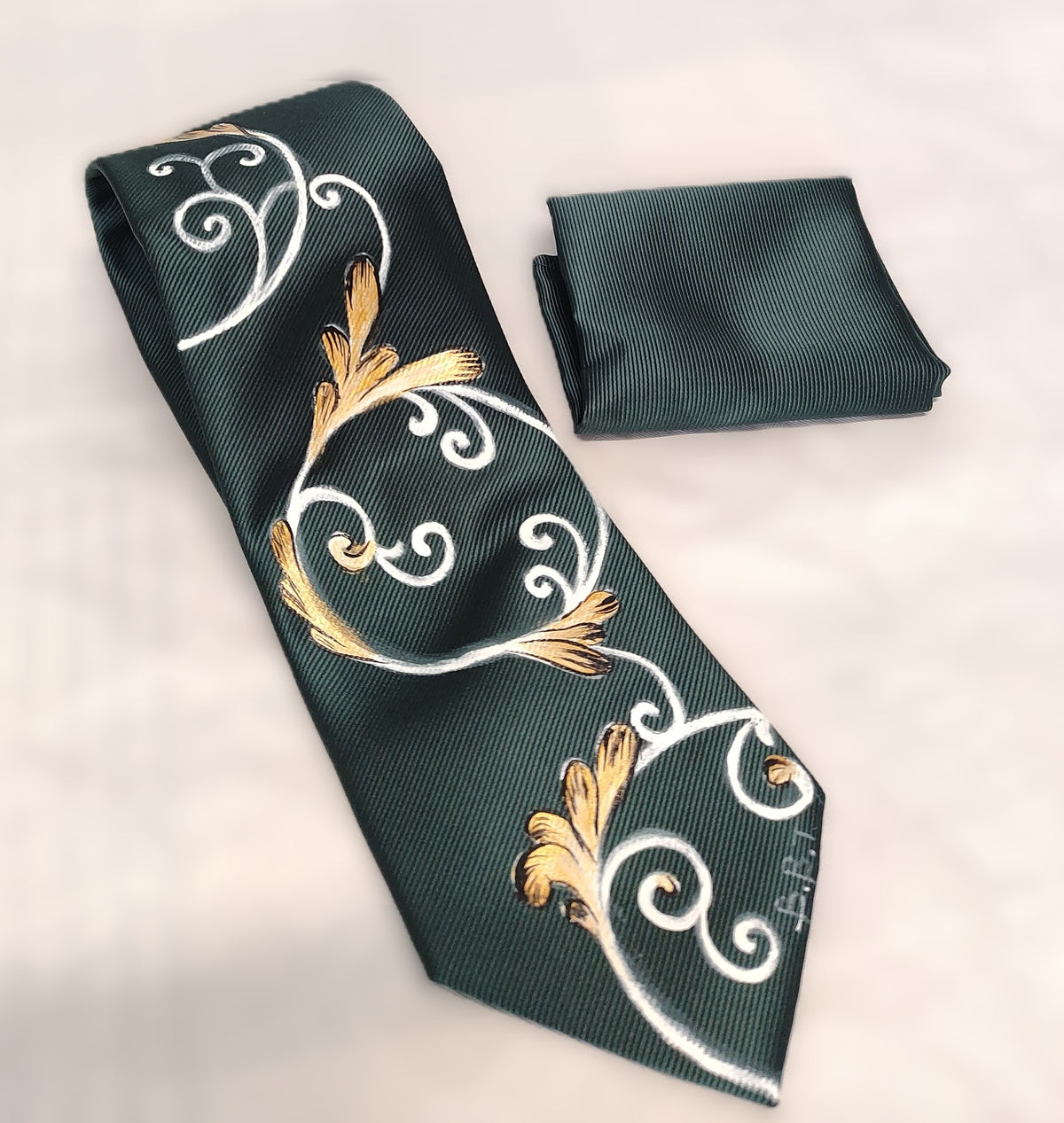 Cravatta verde scuro con ghirigori bianchi e oro