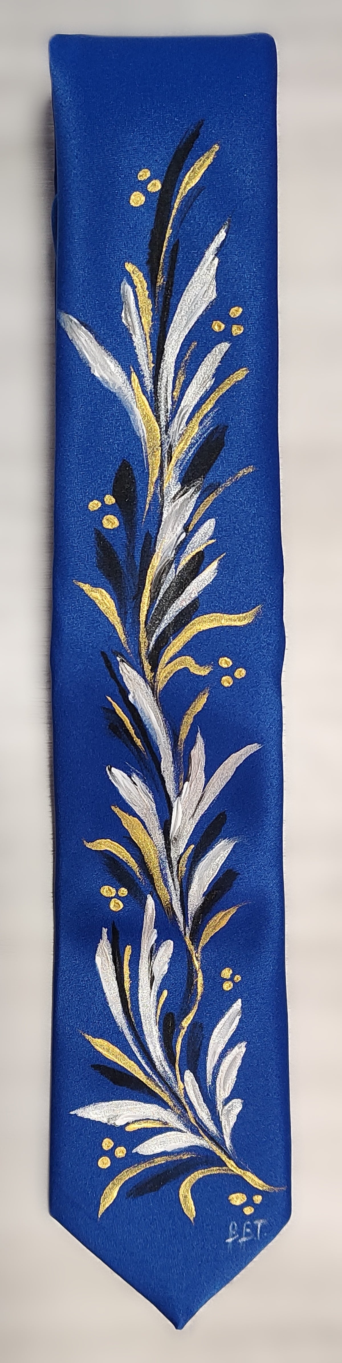 Cravatta blu con rami bianchi e oro